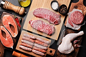 Various raw meat and fish. Steaks, sausages, salmon, chicken and spices