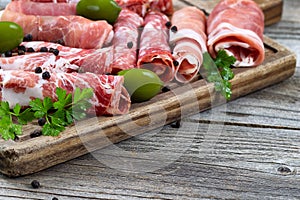 Various raw meats on serving board with rustic background