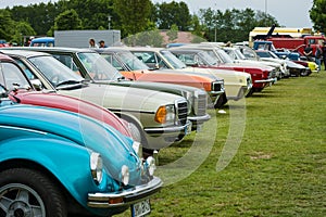 Various retro cars standing in a row in the exhibition field.