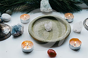 various rocks and stones surrounding a large bowl with candles in it