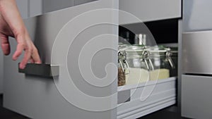 Various seeds in storage jars in hutch, white modern kitchen in background. Smart kitchen organization