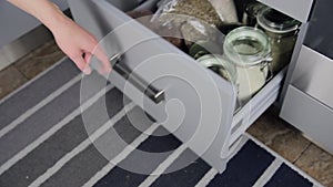 Various seeds in storage jars in hutch, white modern kitchen in background. Smart kitchen organization