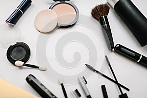 Various set makeup products: brushes, eyeshadow, powder, mascara, cosmetics isolated on light white background.