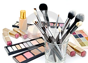 Various set of professional makeup brushes and cosmetics and palette of colourful eye shadows isolated