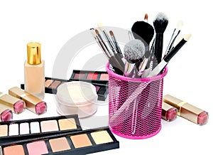 Various set of professional makeup brushes and cosmetics and palette of colourful eye shadows isolated