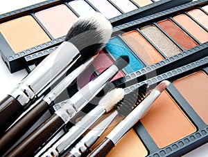 Various set of professional makeup brushes and palette of colourful eye shadows