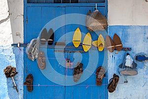 Various sets of shoes hanging on a blue doorway at Kasbah des Oudaias in Rabat in Morocco.