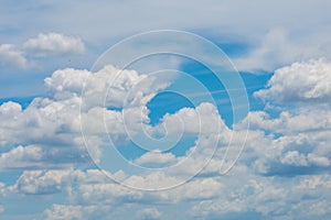 Various shape fluffy cummulus clouds accumulating on blue summer sky
