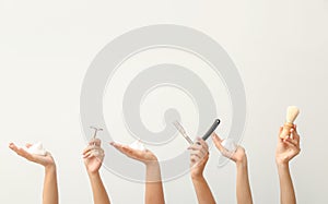 Hands with different tools for shaving on white background
