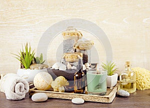 Various spa bath room beauty products on wooden tray with indoor fountain.