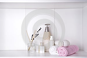Various spa and beauty threatment products on white shelf photo