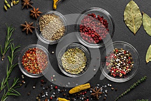 Various spices on a gray background. seasoning in glass cups top view, close-up