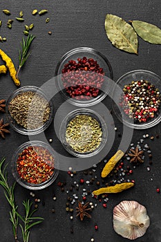 Various spices on a gray background. seasoning in glass cups top view, close-up, vertical photo