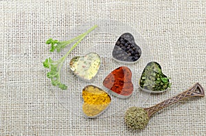 Various spices in heart chaped containers on a tablecloth