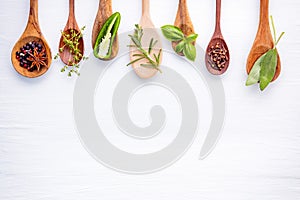 Various of spices and herbs on wooden background. Flat lay spices ingredients rosemary, thyme, oregano, sage leaves and sweet basi