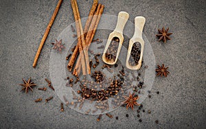 Various of spices and herbs in wooden spoons. Flat lay spices ingredients clove ,peppercorn, cinnamon and star anise on dark stone