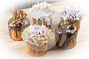 Various Spring Easter cakes with white icing and sugar decor on the table decorated in rustic style