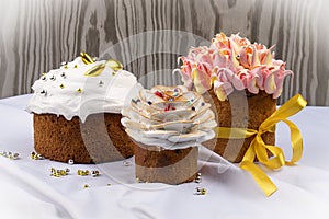 Various Spring Easter cakes with white icing and sugar decor on the table decorated in rustic style