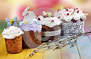 Various Spring Easter cakes with white icing and sugar decor on the table decorated in rustic style