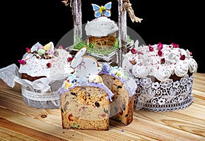 Various Spring Easter cakes with white icing and sugar decor on the table decorated in rustic style