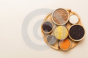 Various superfoods in smal bowl on colored background. Superfood as rice, chia, quinoa, lentils, nuts, sesame seeds