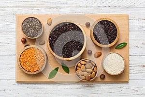 Various superfoods in smal bowl on colored background. Superfood as rice, chia, quinoa, lentils, nuts, sesame seeds