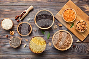 Various superfoods in smal bowl on colored background. Superfood as rice, chia, quinoa, lentils, nuts, sesame seeds