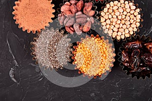 Various superfoods in small bowl on black background