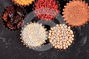 Various superfoods in small bowl on black background