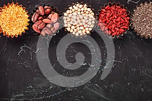 Various superfoods in small bowl on black background