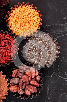 Various superfoods in small bowl on black background