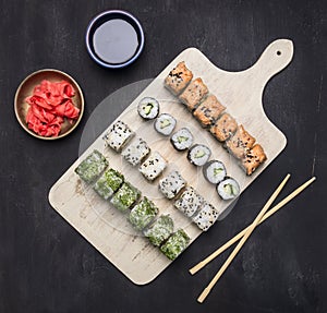 Various sushi sets, dill, salmon, crab on a white cutting board Asian food on wooden rustic background top view close up