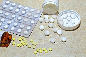 Various tablets - analgesics, antidepressants, vitamins, antiviral drugs scattered on the table.