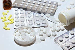 Various tablets - analgesics, antidepressants, vitamins, antiviral drugs scattered on a white background.