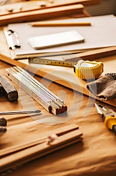 Various tools on carpentry woodwork workshop desk, selective focus