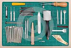 Various tools for leatherwork on self-healing mat