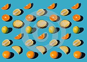 Various type of citrus fruits shaped in pattern on blue background. Slices of tropic fruits collection. Summer time mix