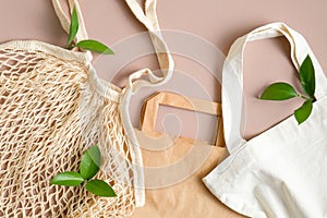 Various type of eco-friendly produce bags. Reusable grocery mesh bag, paper bag and cotton bag on brown background