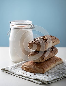 Various types of bread with flour jar on the side