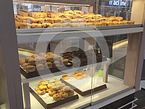 Various types of breads are displayed for sale inside the bakery display rack.