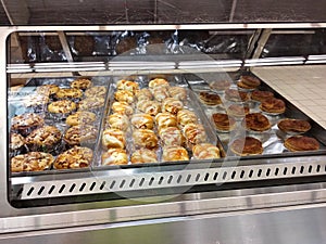 Various types of breads are displayed for sale inside the bakery display rack.