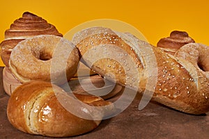Various types of breads and donuts with yellow background photo