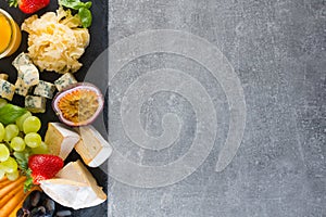 Various types of cheese with fruits and sauces. Empty space background concept