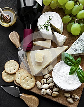 Various types of cheese, grapes and wine