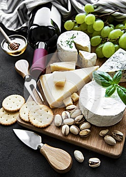 Various types of cheese, grapes and wine