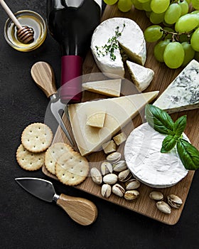 Various types of cheese, grapes and wine