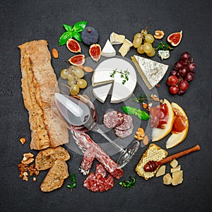 Various types of cheese, meat, fruits and wine