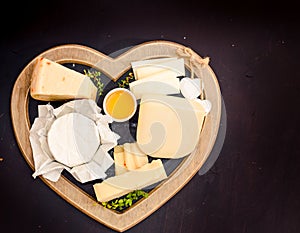 various types of cheese on rustic wooden table, goat cheese, chevre, grana padana