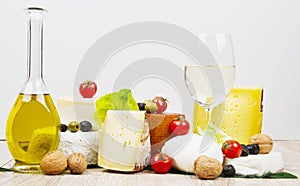 Various types of cheese on white wood