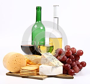 Various types of cheese, wine, grapes and crackers